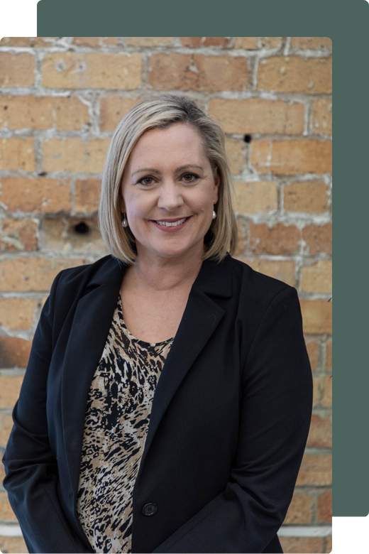 Professional headshot of Jenny Turner in a black blazer against a brick wall. Professional headshot of Jenny Turner in a black blazer against a brick wall.