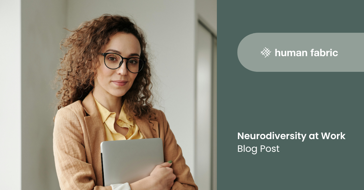 A woman holding her laptop, looking at the camera and half smiling.