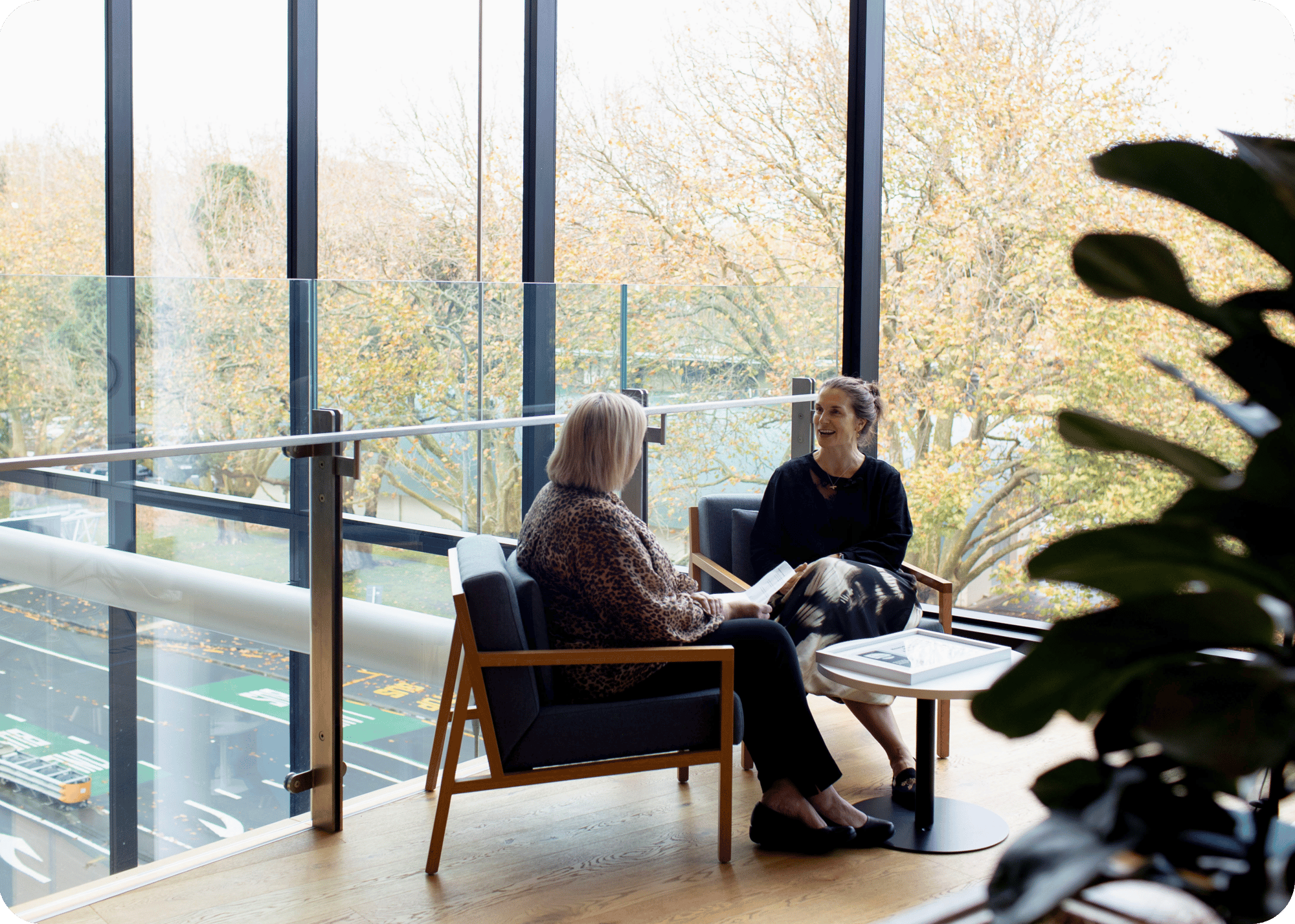 Two people talking on chairs in an office setting
