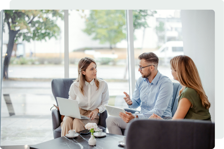 three colleagues talking to each other in a bright modern room with a glass window in the background three colleagues talking to each other in a bright modern room with a glass window in the background