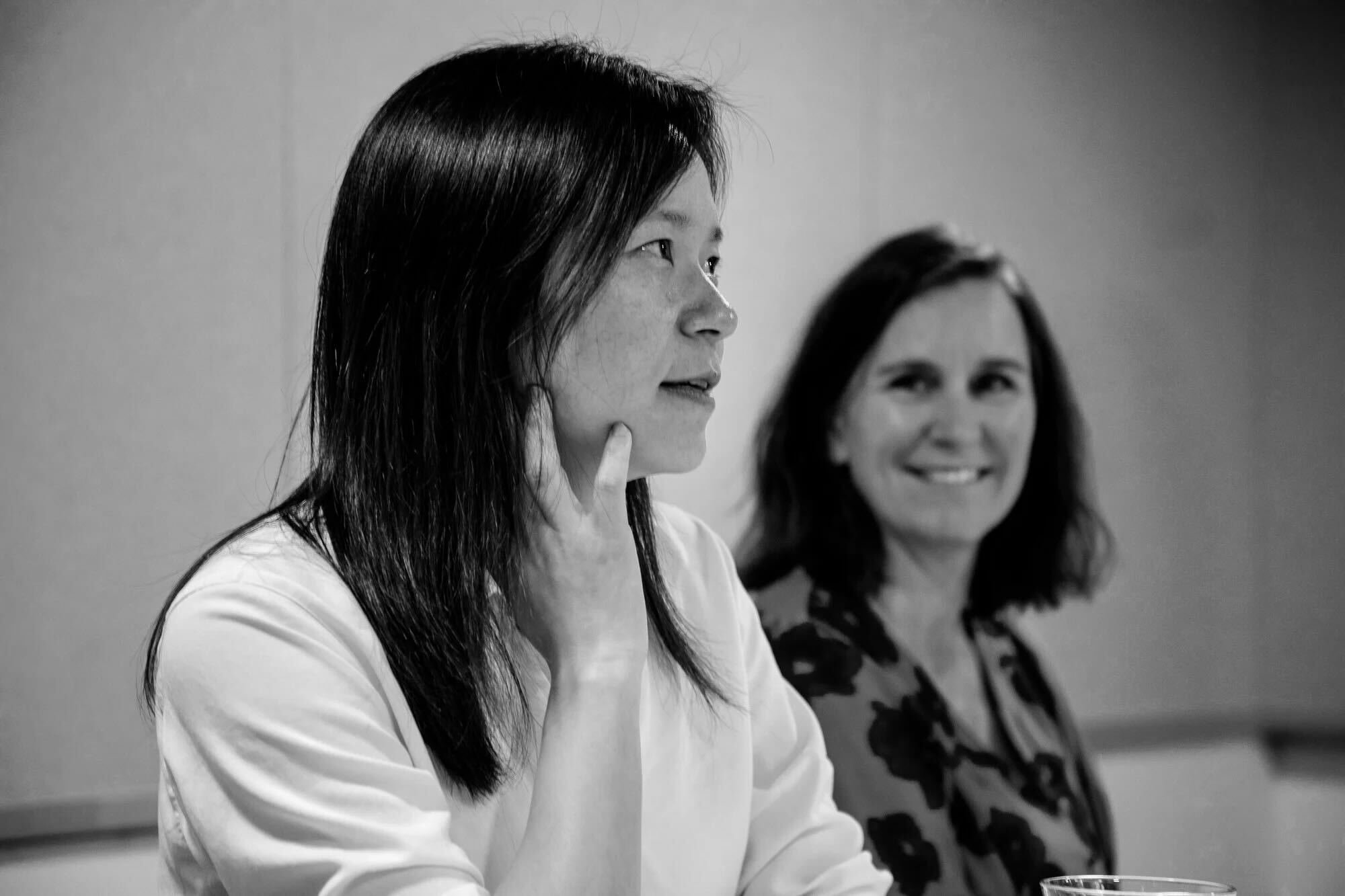 Two people in a workshop looking engaged. Two people in a workshop looking engaged.