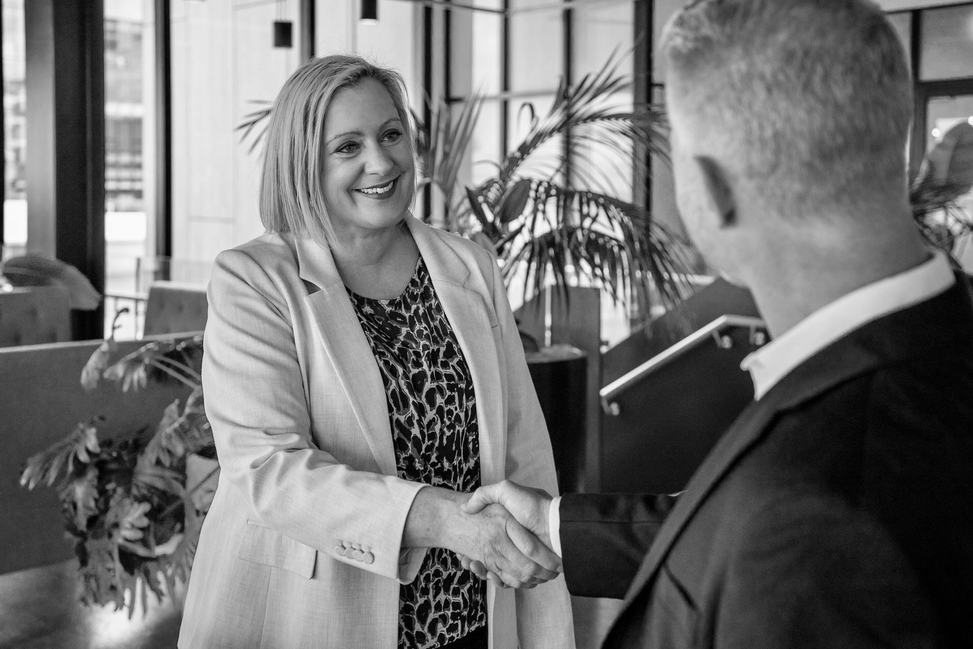 Jenny shaking a hand of a man in a suit