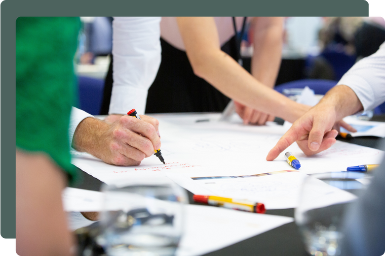 office workers pointing at pieces of paper on a table office workers pointing at pieces of paper on a table